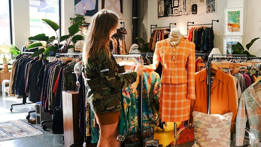 Test din modebrand med lokale pop-ups og markedsfeedback Lille tøjmærkebod på en lokal markedsplads med håndlavede skilte